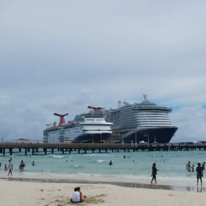 Multiple cruise ships docked at port during a beach day